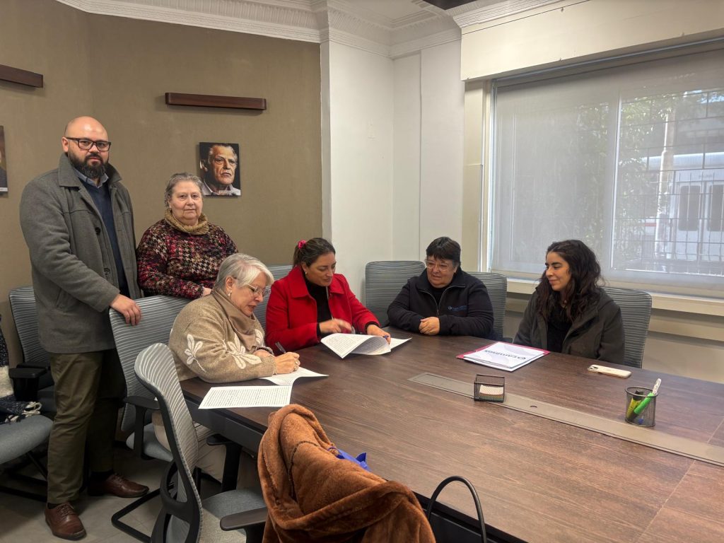 Representantes de ONAJPU y Cooperativa Caminos realizando la firma de Convenio