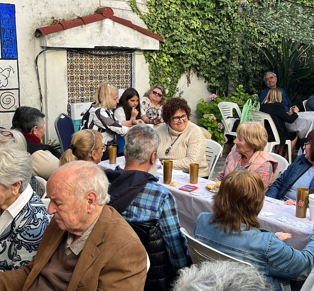 Grupo de adultos mayores jugando al bingo en un patio.